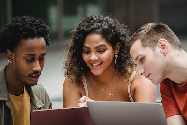 três alunos estudam em grupo