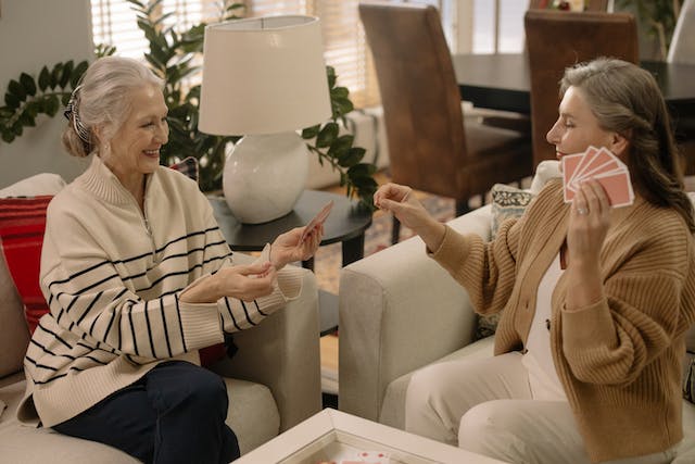 duas mulheres idosas a jogar àr cartas sentadas no sofá