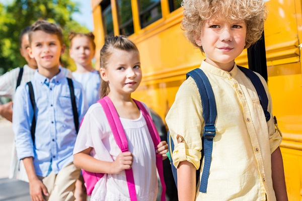 crianças em fila para entrar em autocarro escolar