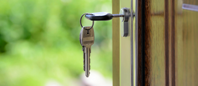 Chave pendurada de uma porta, com outra dentro da fechadura, para mostrar domicílio fiscal do Certificado de Residência Fiscal.